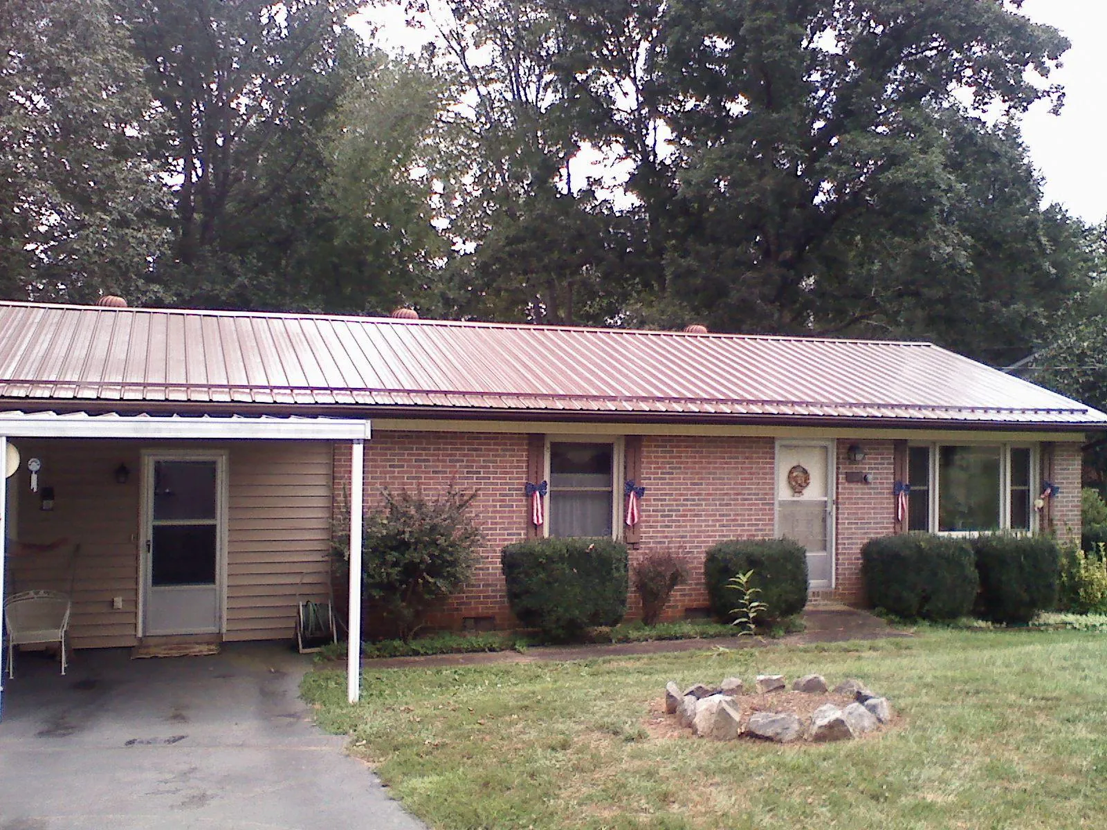 Bronze metal roof and carport on a brick ranch home — Roof Repair work by our crew in Butler